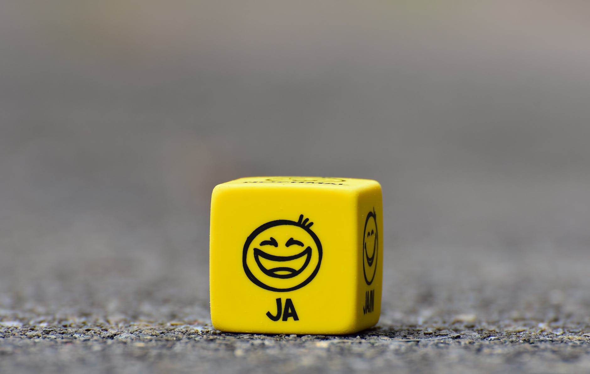 yellow cube on brown pavement